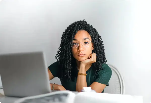 Person thinking while sitting behind a laptop